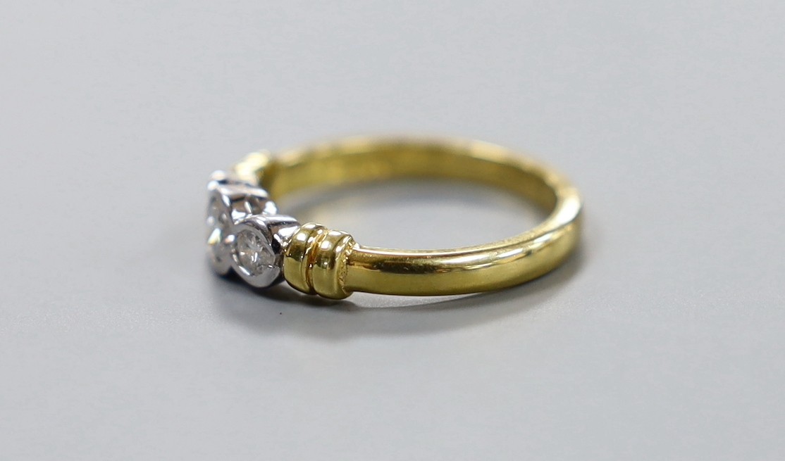 A modern 18ct gold and collet set three stone diamond ring, size O, gross weight 4.6 grams